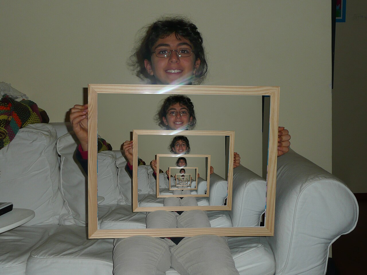 The same photograph, but now the frame holds a smaller copy of the whole photo, which holds a smaller copy again, repeating inward.